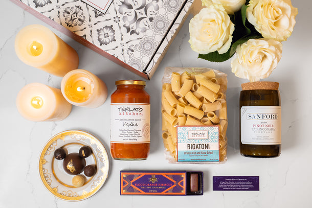 An open blue Terlato Kitchen gift box with two Bloody Mary mixes, olives and cocktail picks.