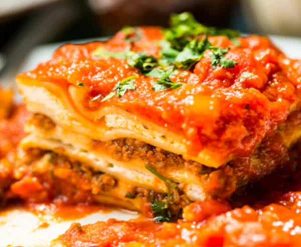 Slice of layered lasagna in signature tomato sauce